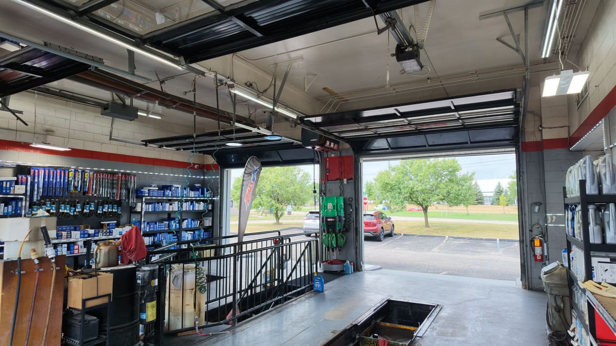 Inside the Sterling Quick Lube service bay looking out toward Van Dyke Ave, with motor oil and filters stocked on the shelves