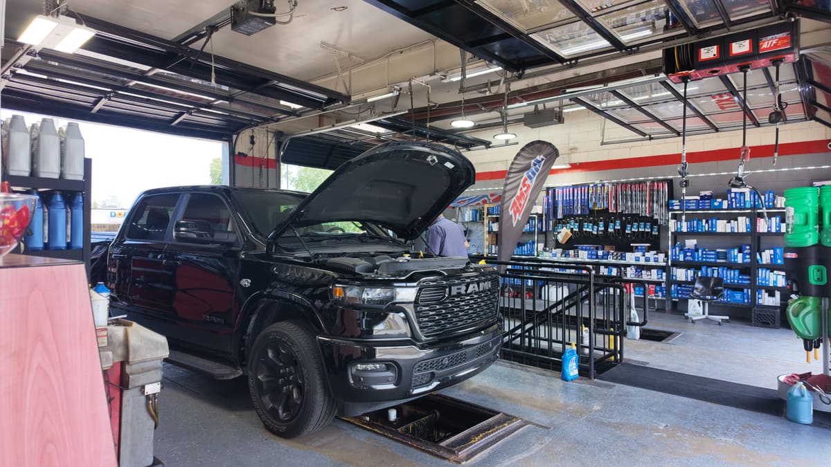 Black Ram pickup truck with its hood raised in the Sterling Quick Lube service bay in Sterling Heights